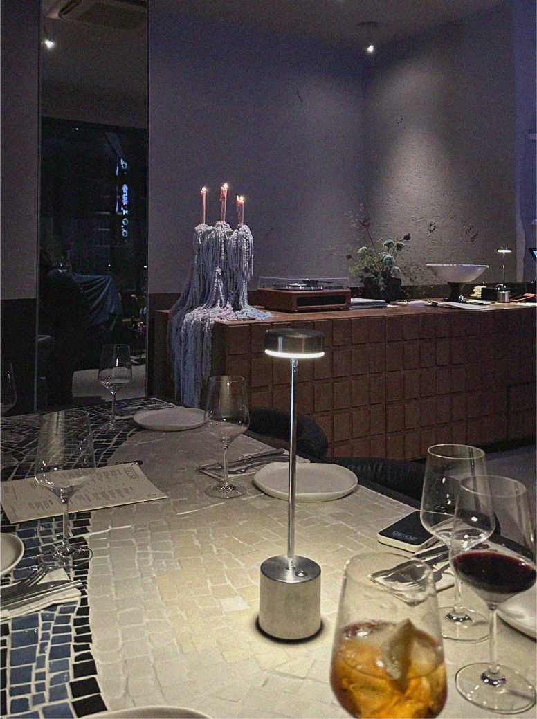 Communal marble table under pink neon at Optimist Bali